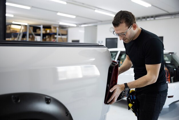 Coup moyen homme fixant une voiture