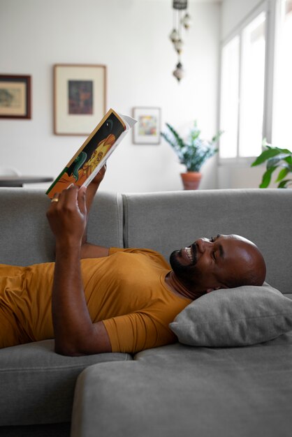 Coup moyen homme lisant des bandes dessinées à la maison