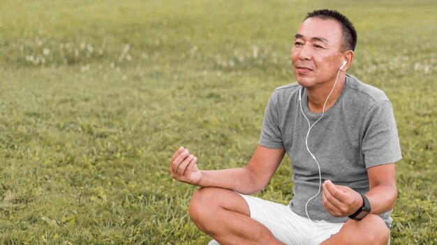 Coup moyen homme méditant sur l'herbe