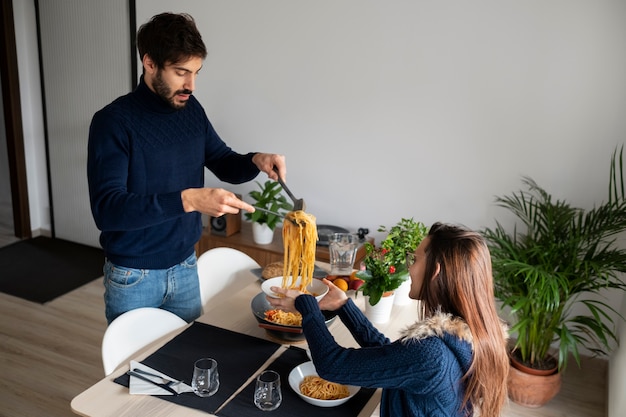 Coup moyen homme mettant des pâtes sur une assiette