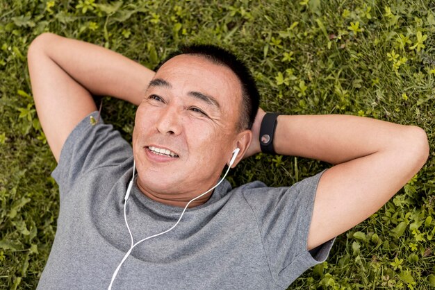 Coup moyen homme portant sur l'herbe