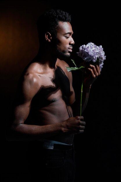 Coup moyen homme posant avec fleur