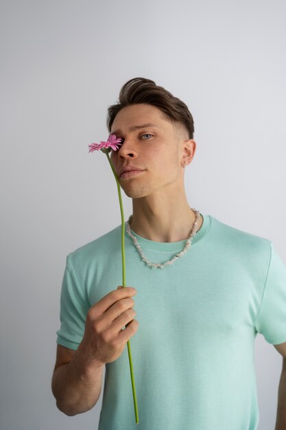 Coup moyen homme posant avec fleur