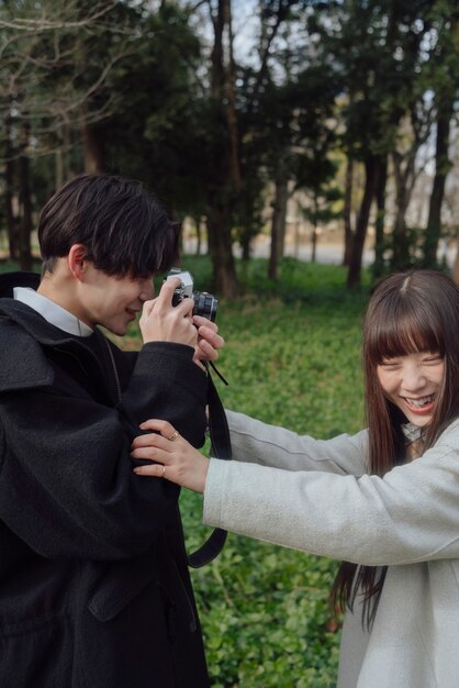 Coup moyen homme prenant des photos d'une femme souriante