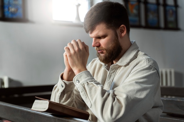 Photo gratuite coup moyen homme priant à l'église