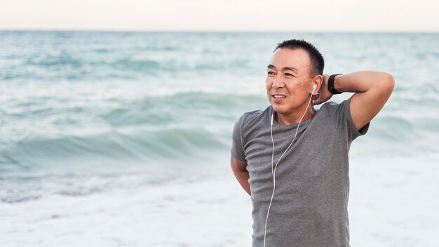 Coup moyen homme qui s'étend sur la plage