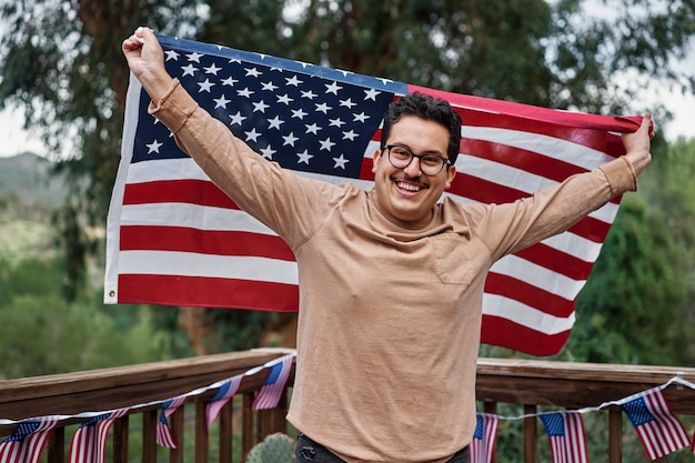 Coup moyen homme souriant tenant le drapeau américain