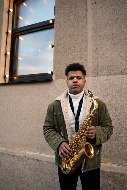 Coup moyen homme tenant le saxophone