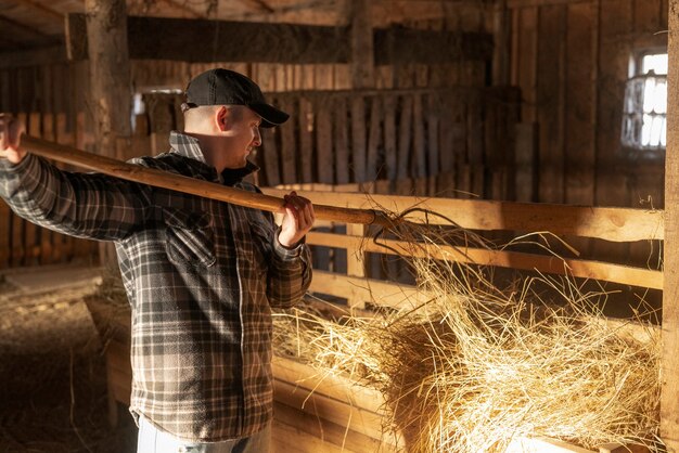 Coup moyen homme travaillant dans la vie rurale de la grange