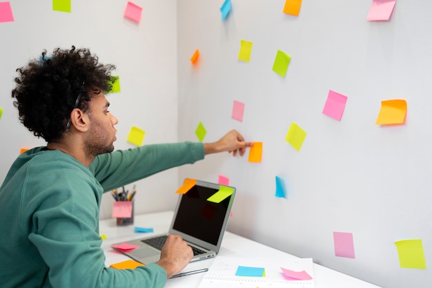 Coup moyen homme travaillant avec un ordinateur portable au bureau