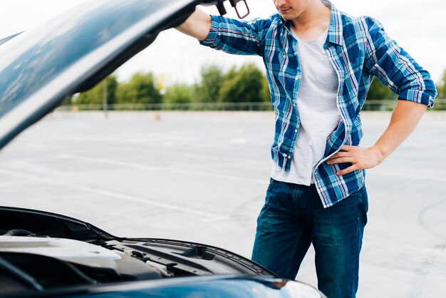 Coup moyen d'homme vérifiant le moteur