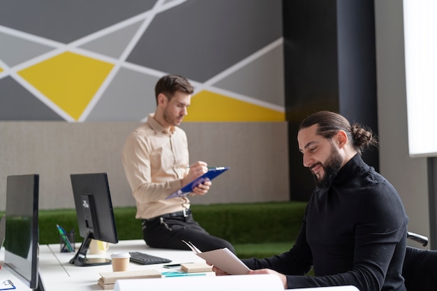 Photo gratuite coup moyen d'hommes au bureau travaillant