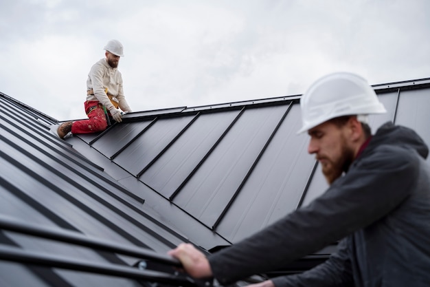 Coup moyen d'hommes travaillant sur le toit