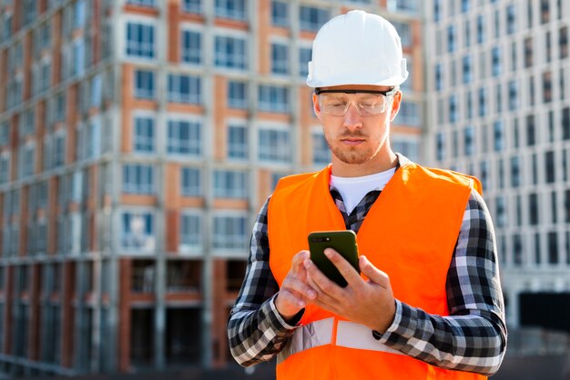 Coup moyen d&#39;ingénieur regardant téléphone