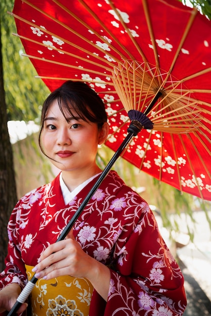 Coup moyen jeune femme tenant un parapluie wagasa