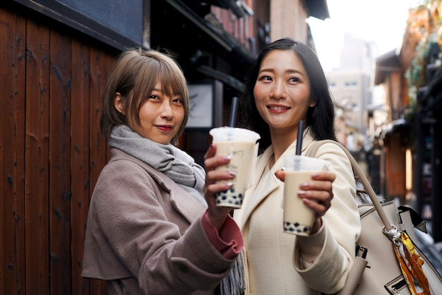 Photo gratuite coup moyen de jeunes femmes avec du thé à bulles