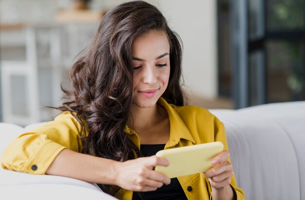 Coup moyen jolie femme jouant au téléphone