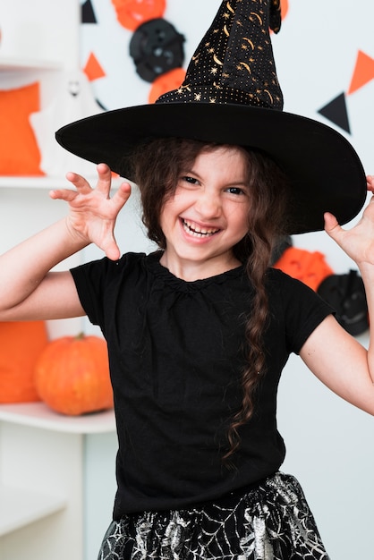 Coup moyen de jolie petite fille avec un chapeau de sorcière