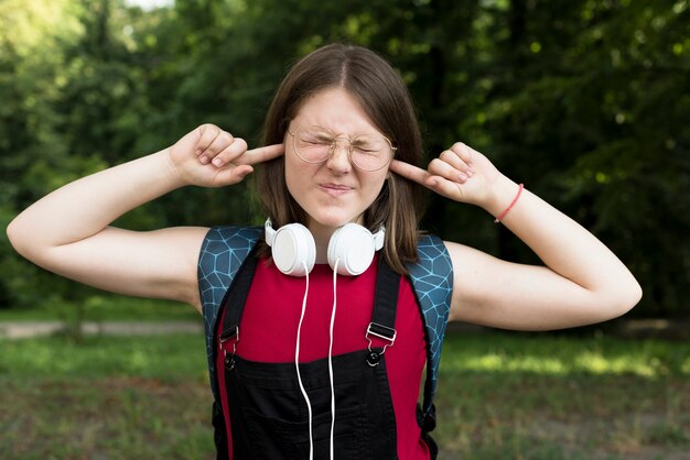 Coup moyen de lycéenne couvrant ses oreilles
