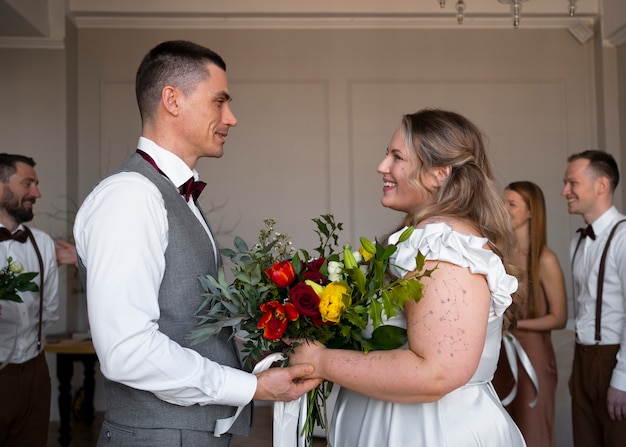 Photo gratuite coup moyen mariée et le marié posant ensemble