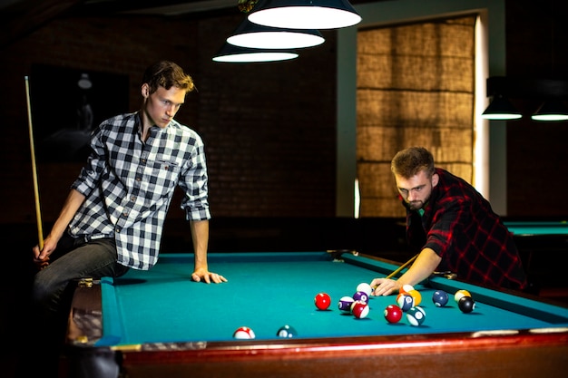 Coup moyen mec assis sur une table de billard