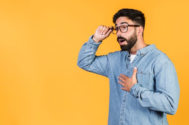 Photo gratuite coup moyen mec choqué tenant ses lunettes