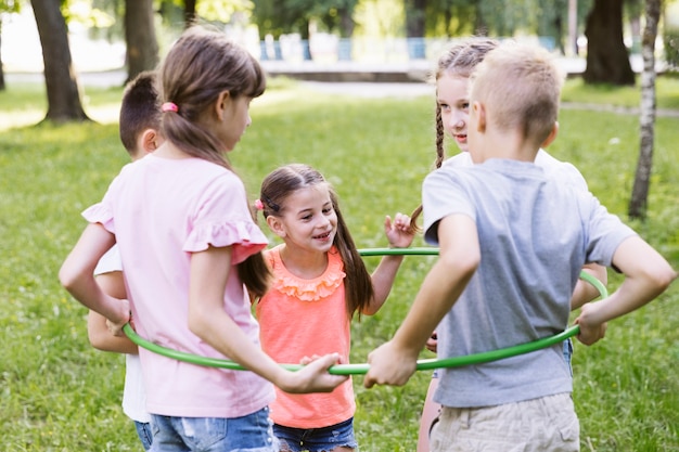 Coup moyen meilleurs amis jouant avec hula hoop