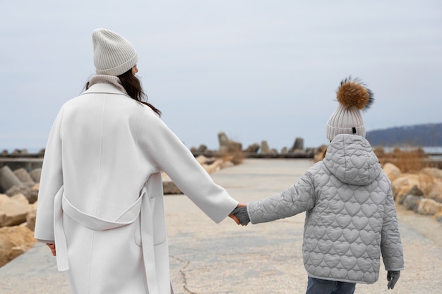 Photo gratuite coup moyen mère et enfant à la plage