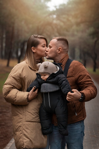 Photo gratuite coup moyen parents s'embrassant à l'extérieur