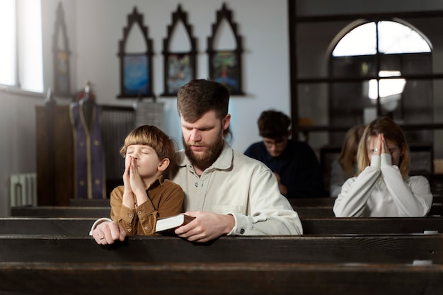 Photo gratuite coup moyen père chrétien et fils à l'église