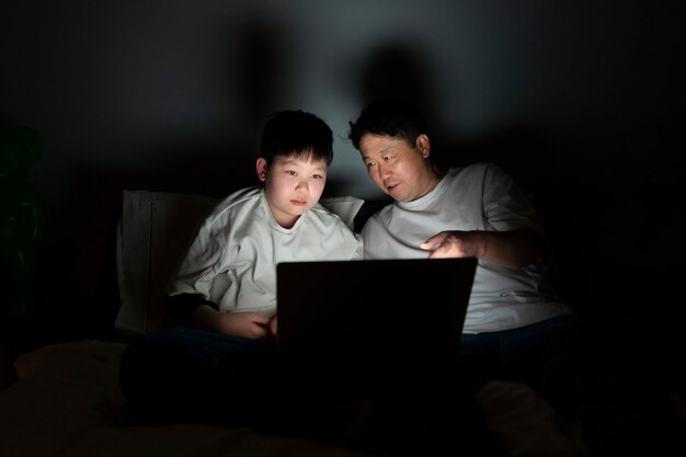 Coup moyen père et enfant avec ordinateur portable
