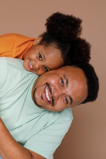 Photo gratuite coup moyen père et fille posant en studio