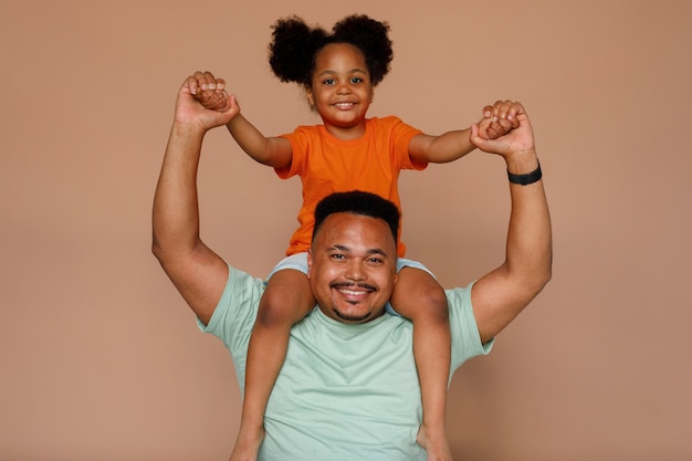 Photo gratuite coup moyen père et fille posant en studio