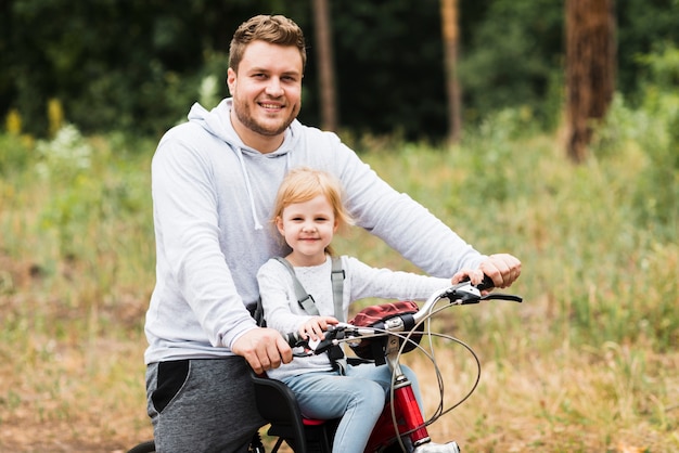 Photo gratuite coup moyen père et fille en vélo