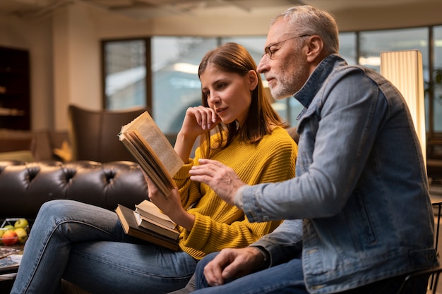 Photo gratuite coup moyen de personnes lisant à l'intérieur