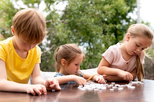 Photo gratuite coup moyen pour les enfants assis à table