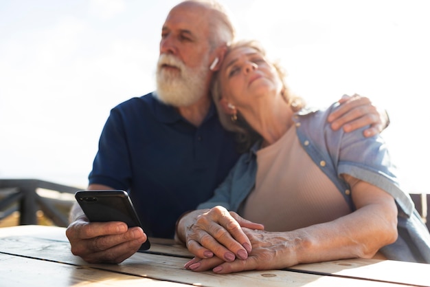 Coup moyen senior couple avec téléphone