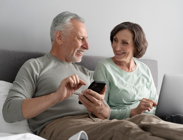 Coup moyen senior couple avec téléphone