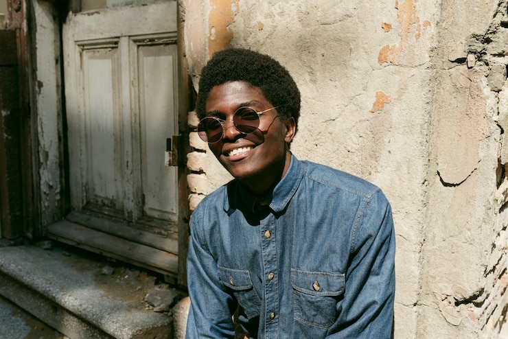 Photo gratuit coup moyen smiley homme noir portant des lunettes de soleil