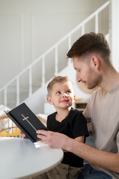 Photo gratuite coup moyen smiley père et garçon avec bible