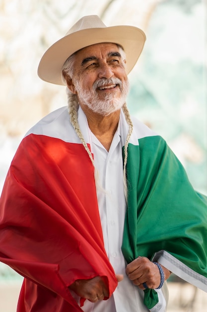 Photo gratuite coup moyen smiley vieil homme portant le drapeau mexicain