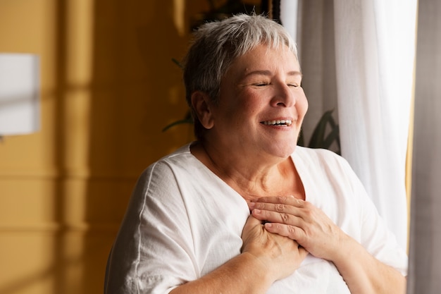 Coup moyen smiley vieille femme à l'intérieur