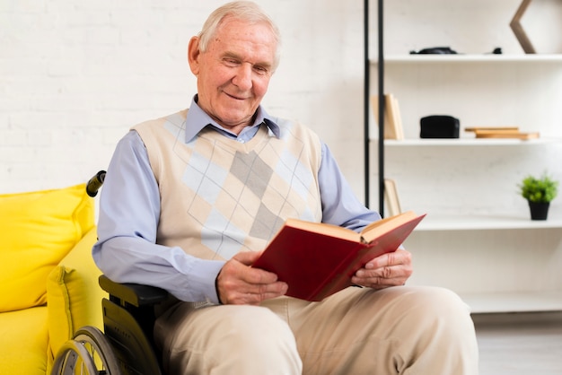 Coup moyen vieil homme assis sur un fauteuil roulant