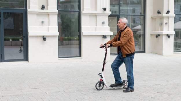 Coup moyen vieil homme avec scooter