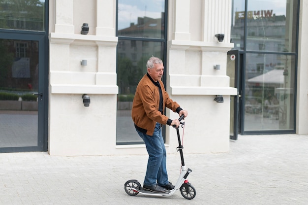 Coup moyen vieil homme sur scooter