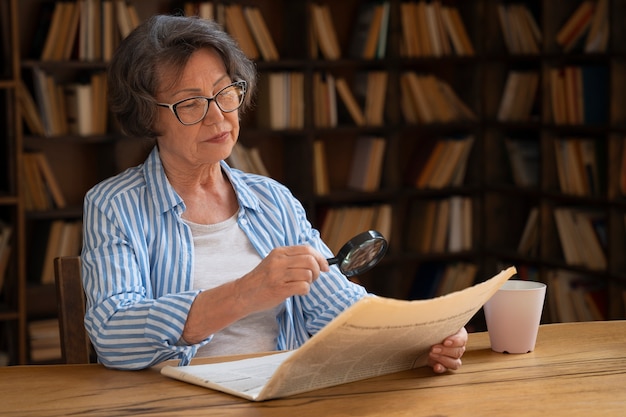 Coup moyen vieille femme dans la bibliothèque