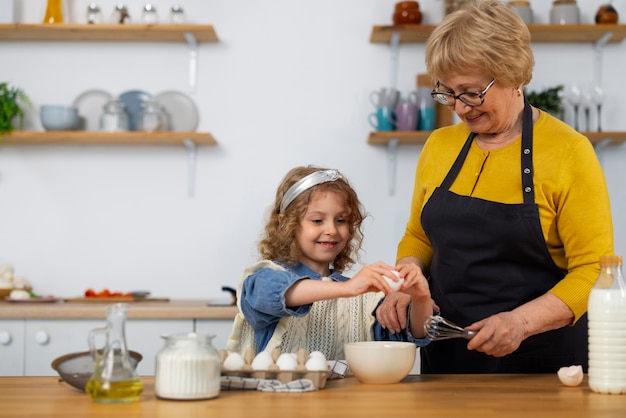 Photo gratuite coup moyen vieille femme et fille dans la cuisine