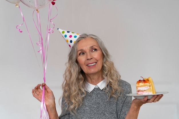 Coup moyen vieille femme tenant un gâteau