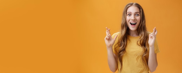 Photo gratuite coup de taille d'une belle femme intéressée, amusée et enthousiaste, en t-shirt décontracté traversant la finge