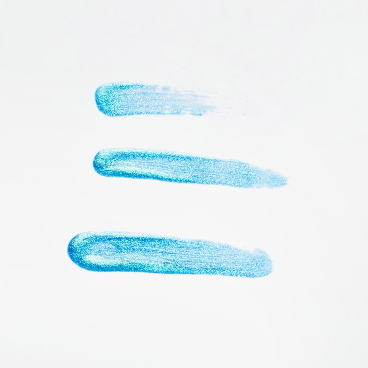 Photo gratuit coup de vernis à ongles paillettes bleu sur fond blanc